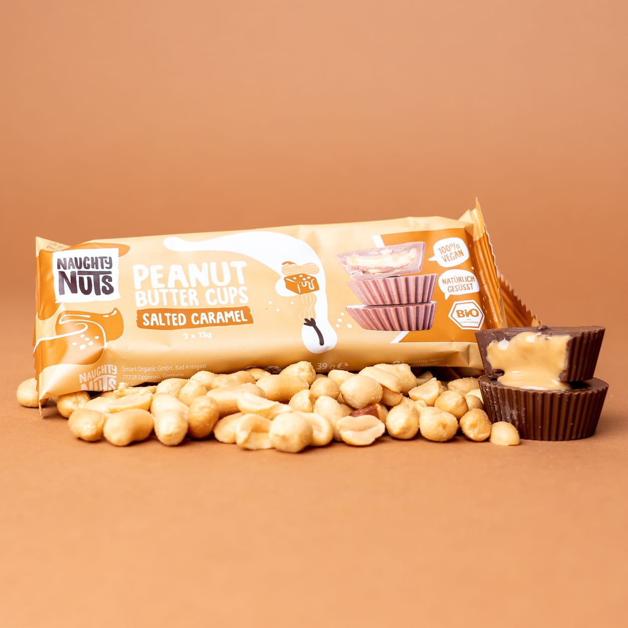 Bio Peanut Butter Cups Salted Caramel Packung mit Erdnüssen und zwei geöffneten Cups